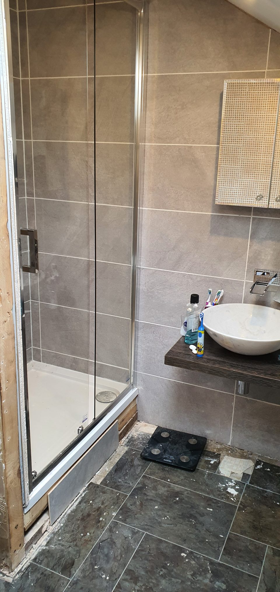 Fitting: large-format grey tiling going up across the walls.