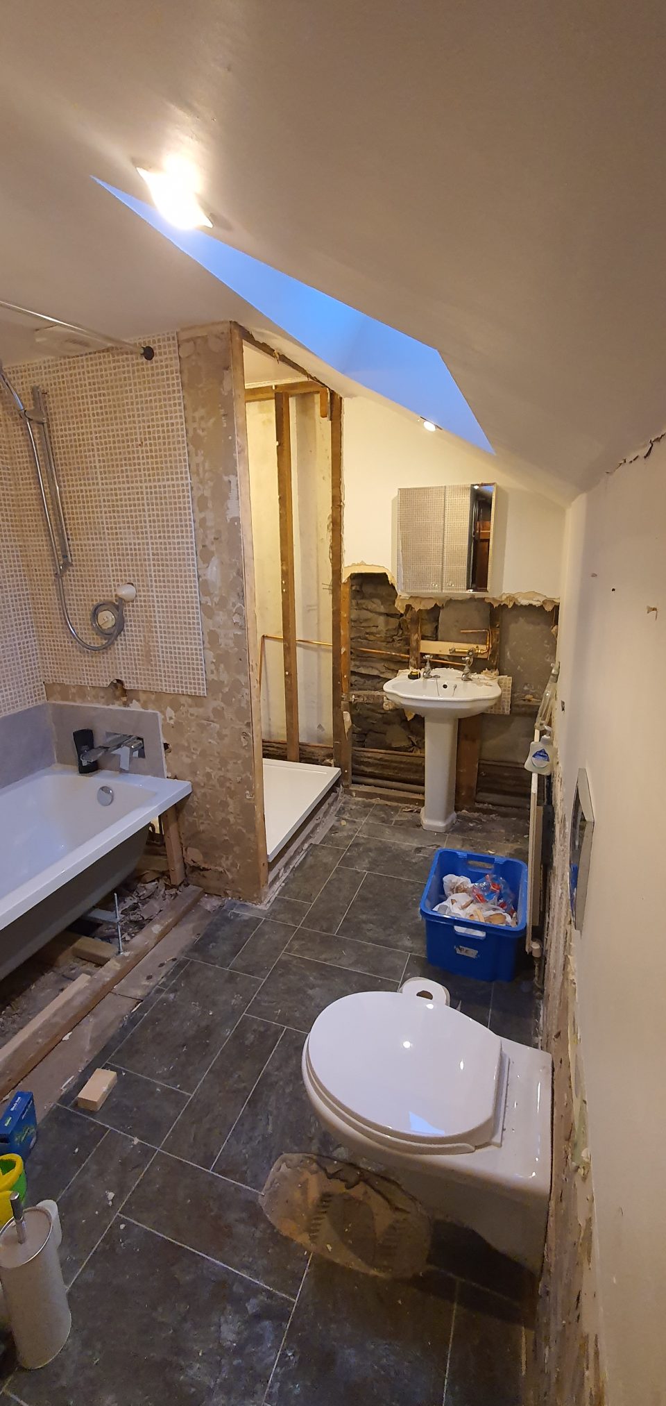 Strip-out: the old suite, tiling and flooring taken back to the walls, ready for new plumbing first-fix.