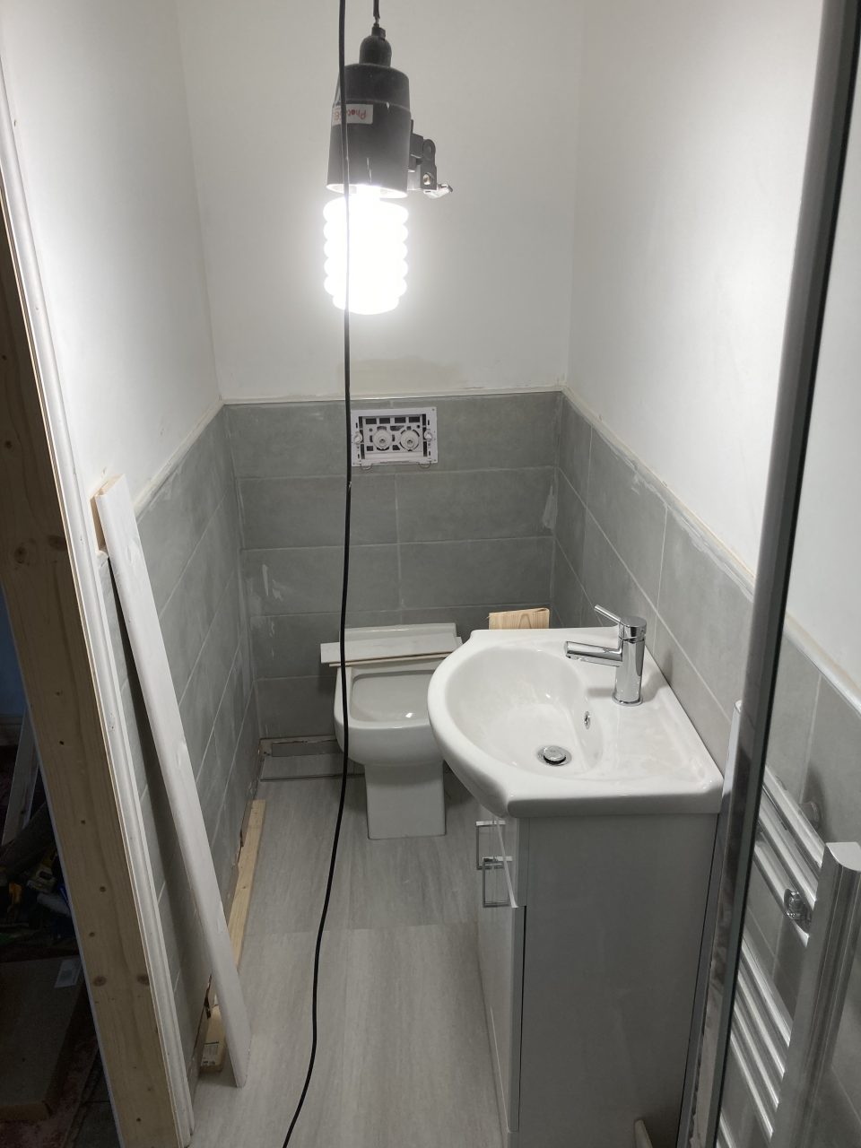 The finished walk-in shower with a rain head, fully tiled.