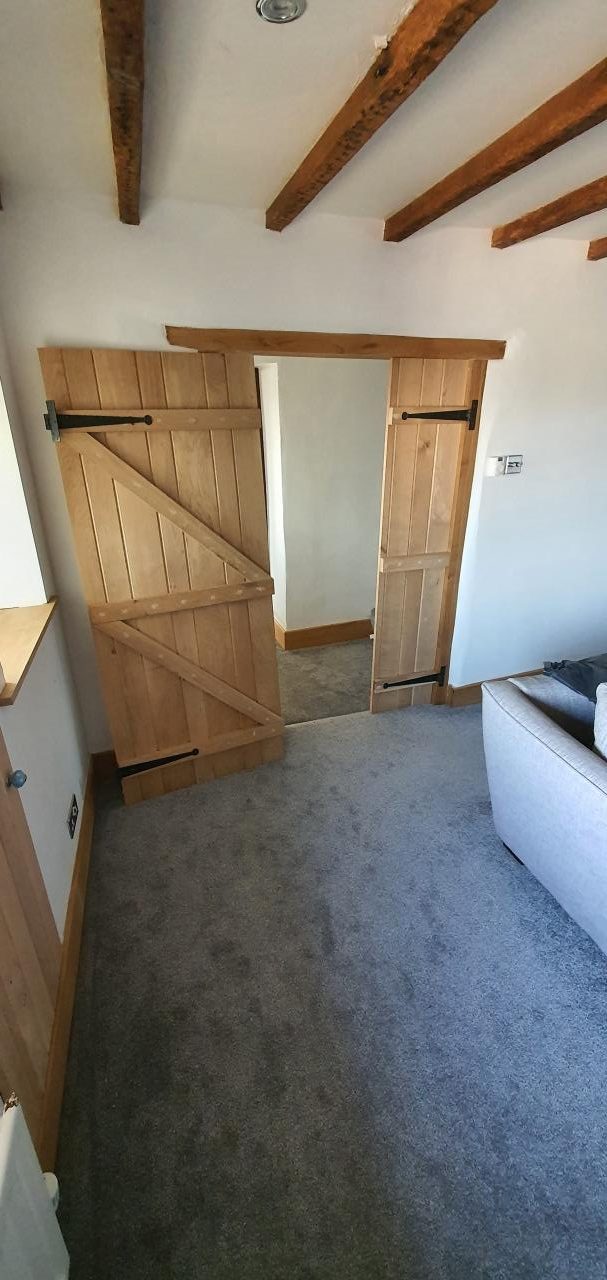 New brace-and-batten oak cottage doors hung throughout the finished room.