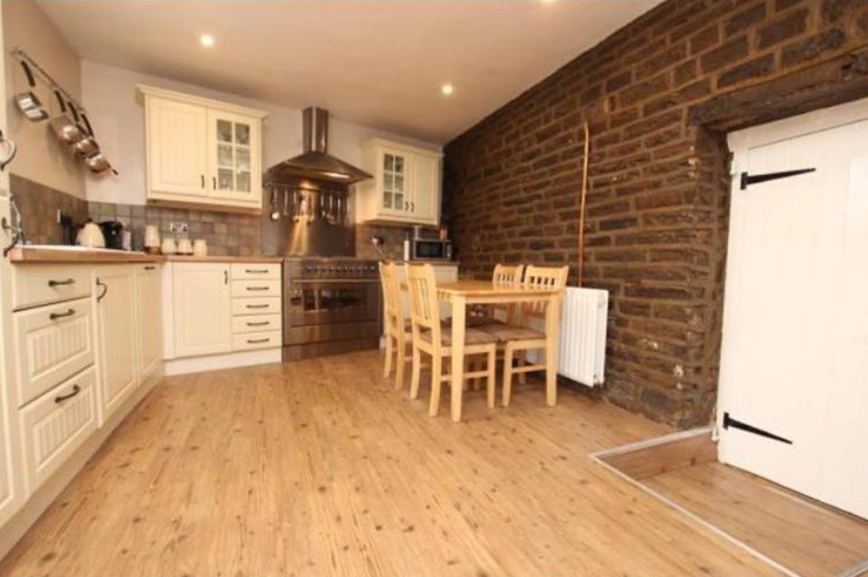 The kitchen before work — a dated cream kitchen with a tiled splashback.