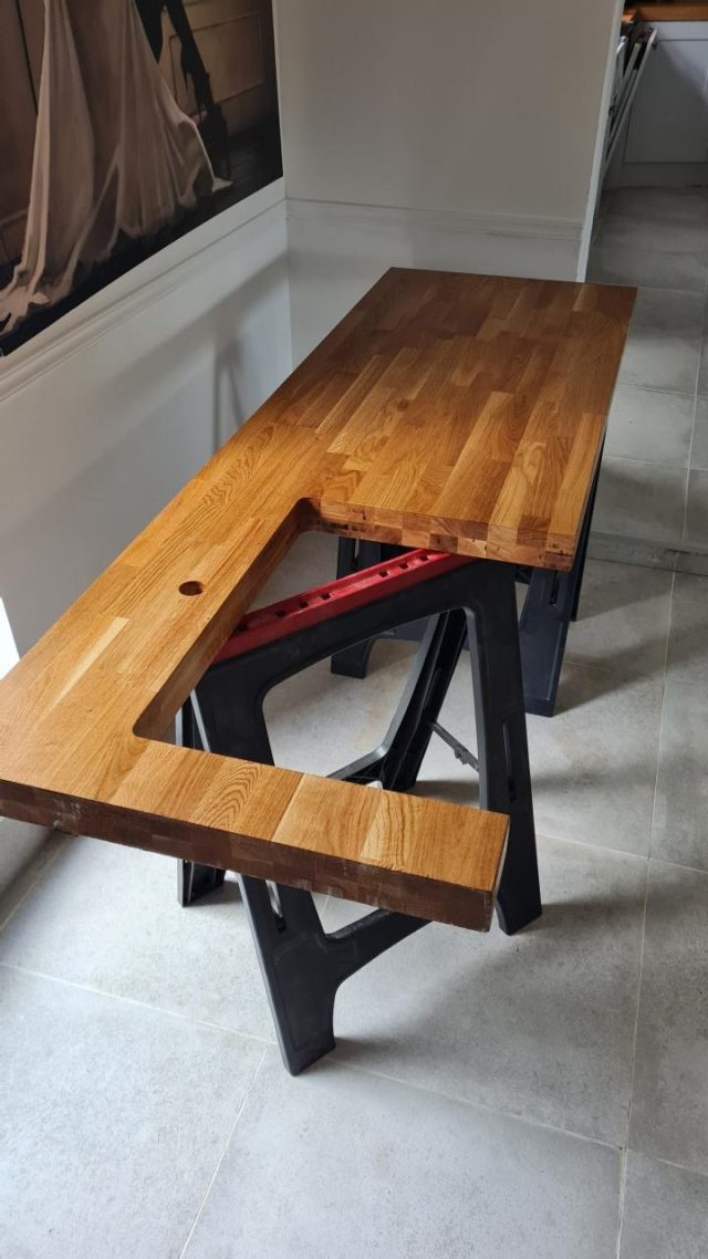 Craftsmanship: the solid oak breakfast-bar worktop being cut and stained by hand.