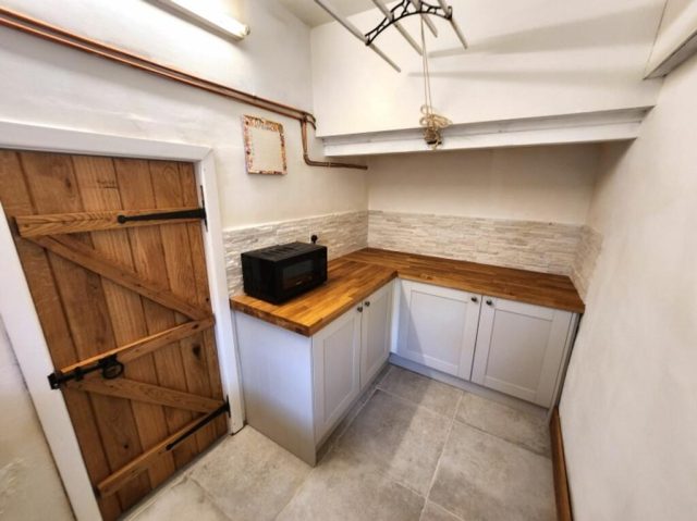 The matching utility room — a Belfast sink set under solid oak worktops.