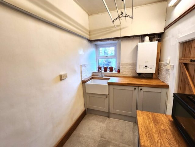 The finished utility room — boxed-in boiler and an oak shelf, finished to match the kitchen.