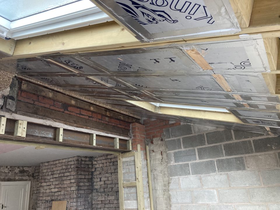 The shell boarded out in pink plasterboard ready for plastering, with the skylight framed into the ceiling.